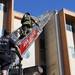 Firefighters climb a ladder to the roof of 611 Church Street on Monday. Ben Freed I AnnArbor.com